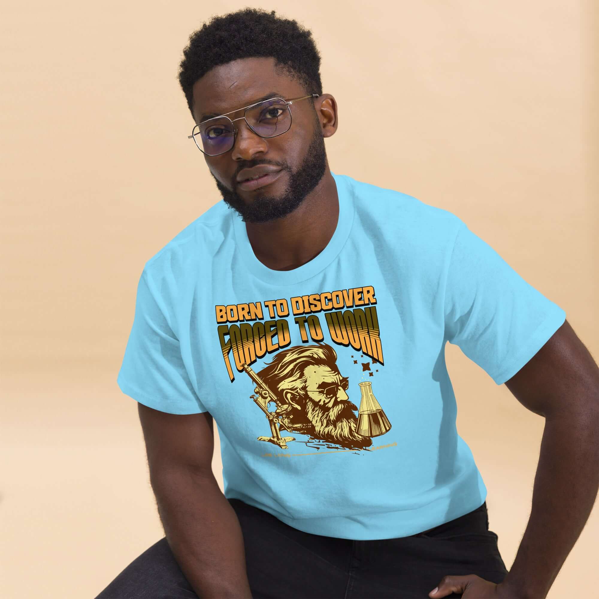 Man wearing 'Born to Discover, Forced to Work' scientist t-shirt with vintage illustration.