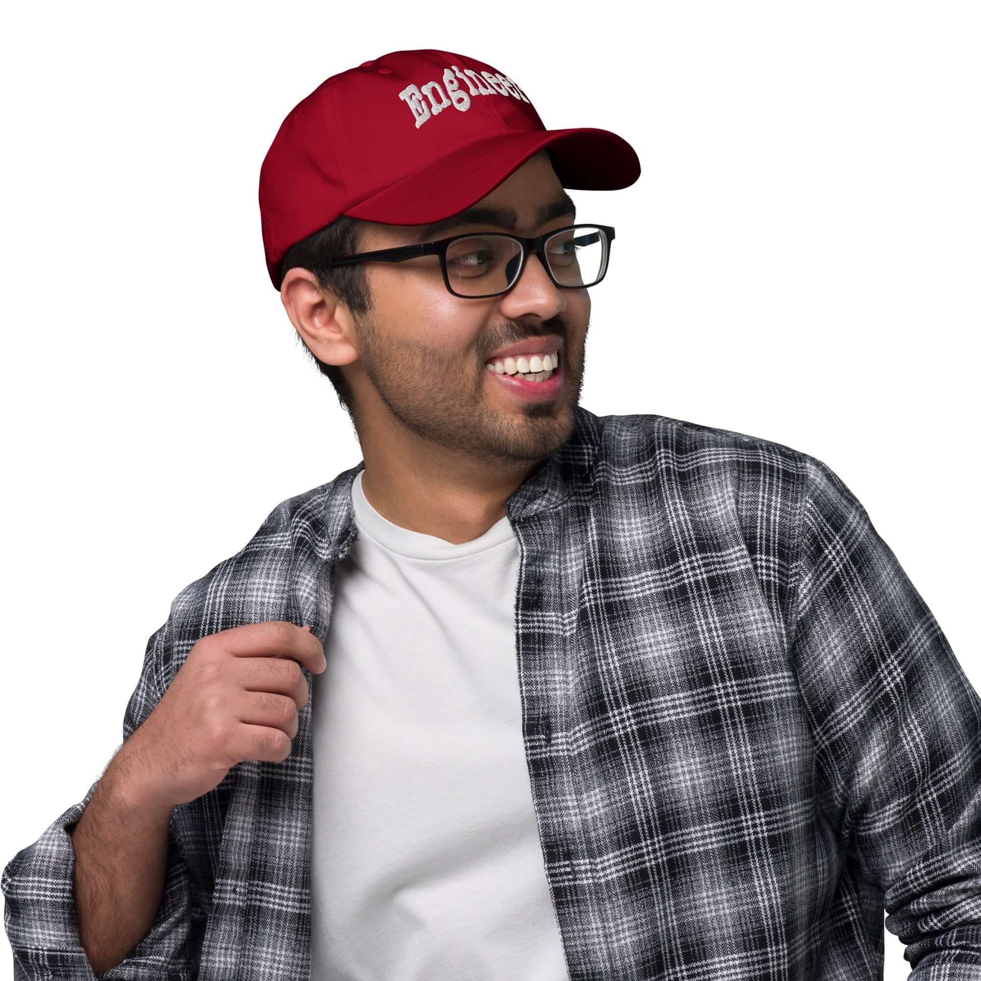 Man wearing red 'Engineer' baseball cap, showcasing problem-solving style with plaid shirt smile.