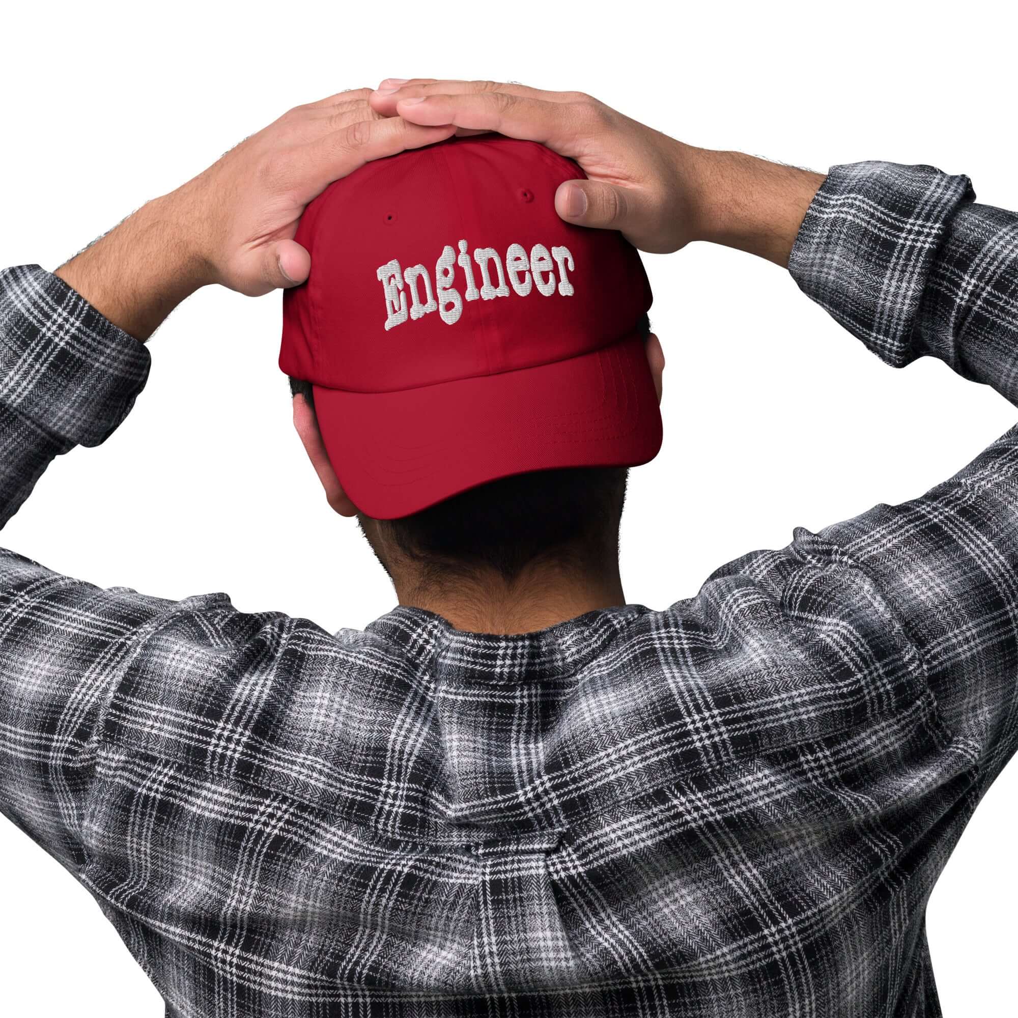 Back view of person wearing red 'Engineer' baseball cap, hands on head, showcasing professional problem-solving headwear.