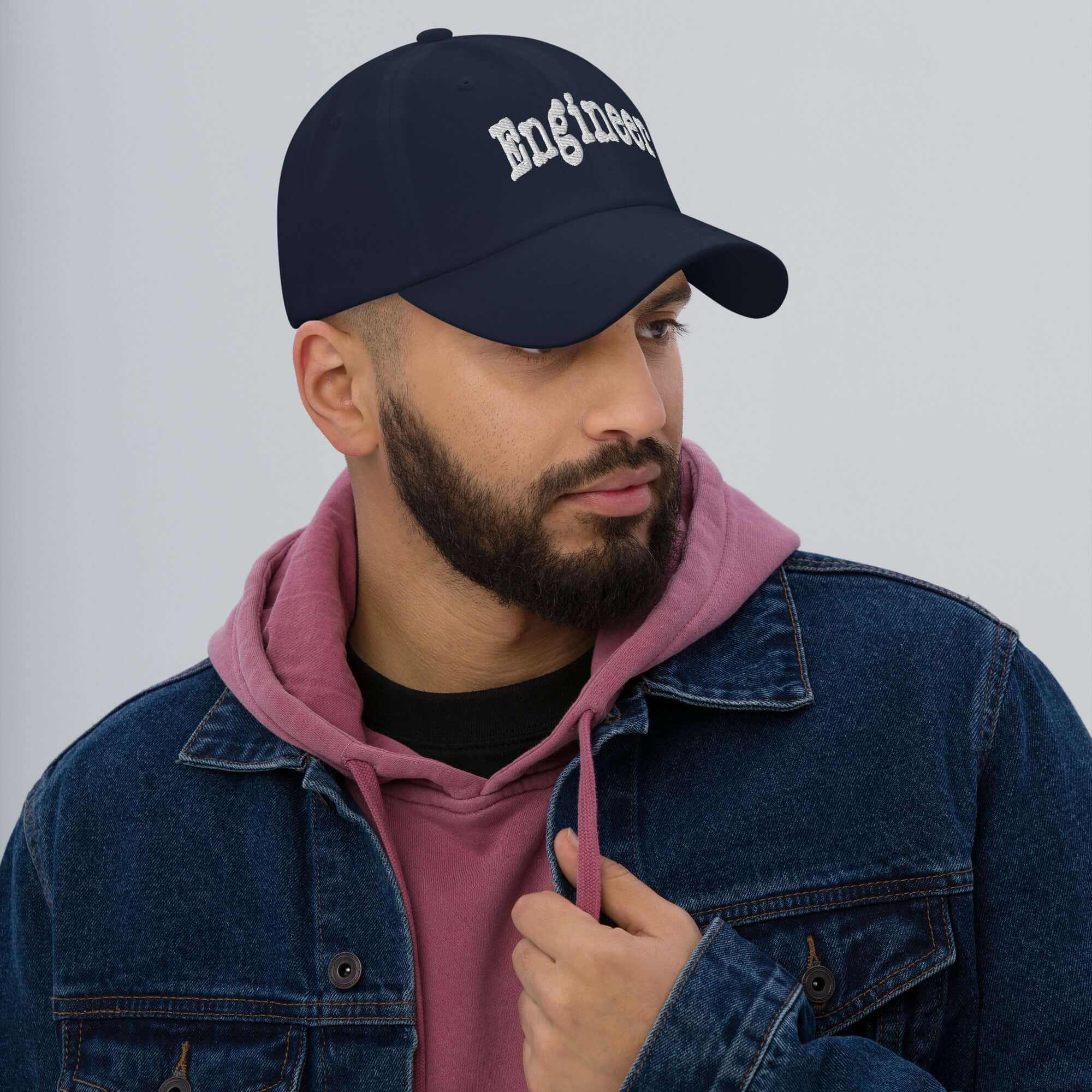 Man wearing Engineer baseball cap, stylish headwear for professional problem solvers, in a casual denim and hoodie outfit.
