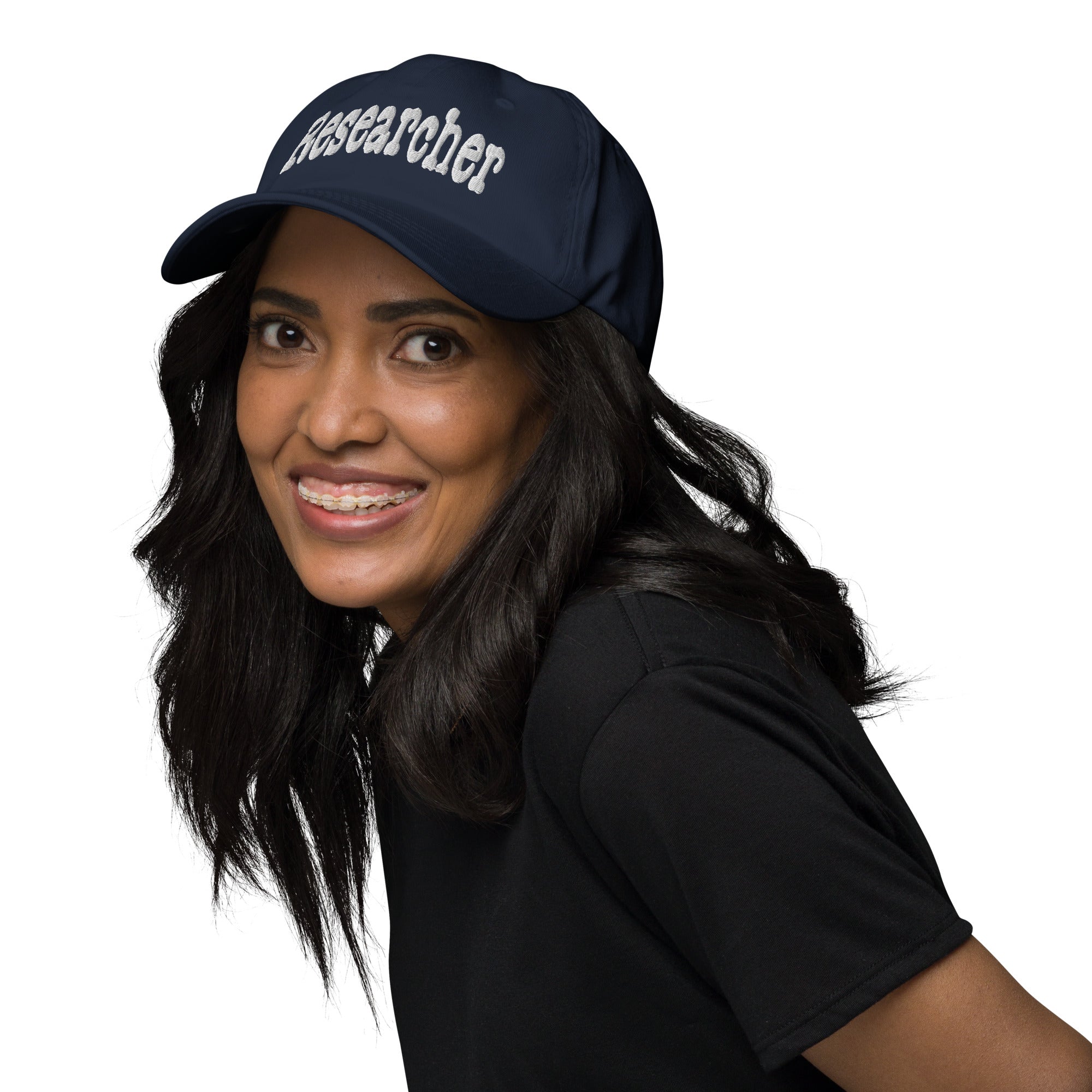 Woman wearing a navy 'RESEARCHER' baseball cap, symbolizing curiosity and professional inquiry.