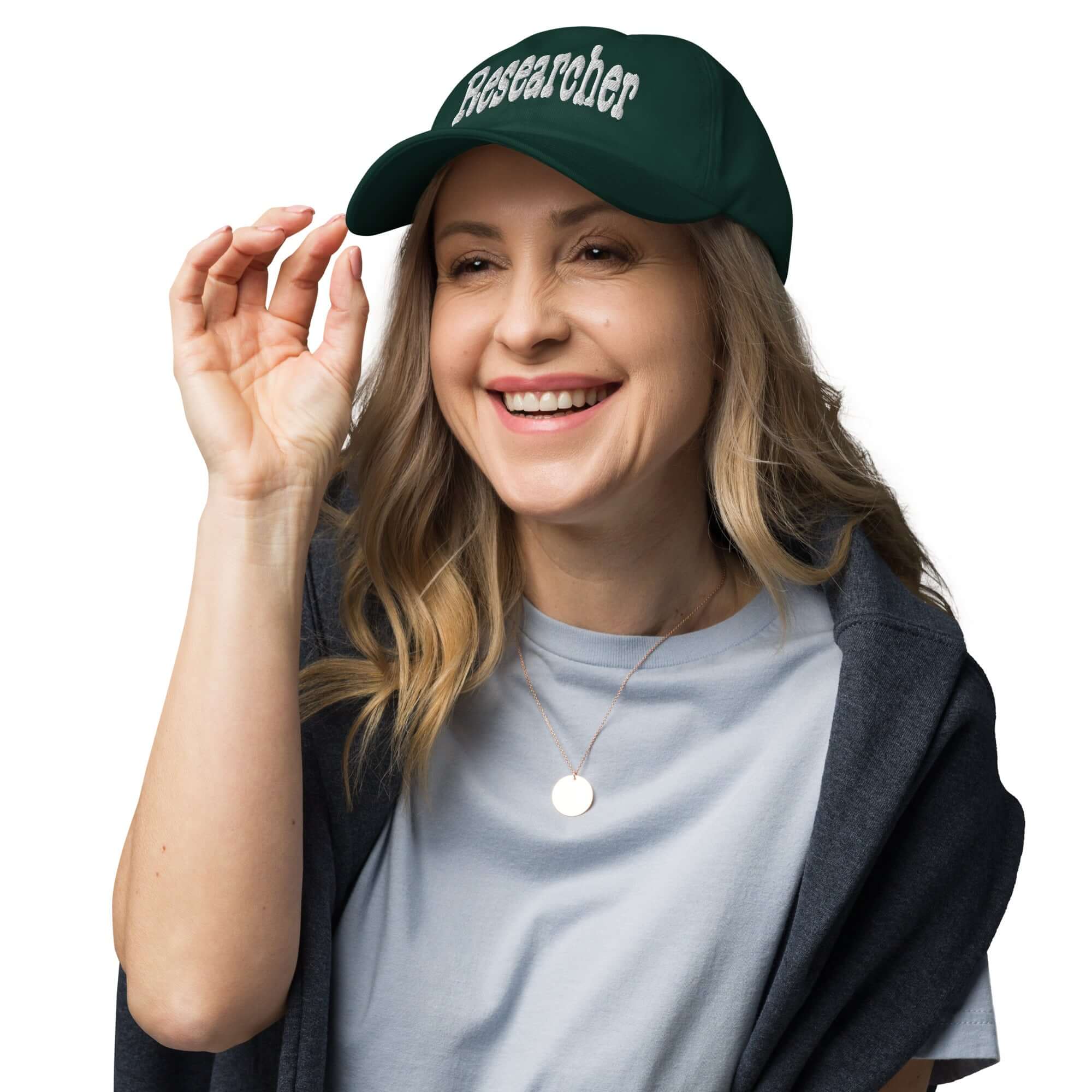Smiling person wearing a dark green "Researcher" baseball cap, symbolizing curiosity and professional question-asking.
